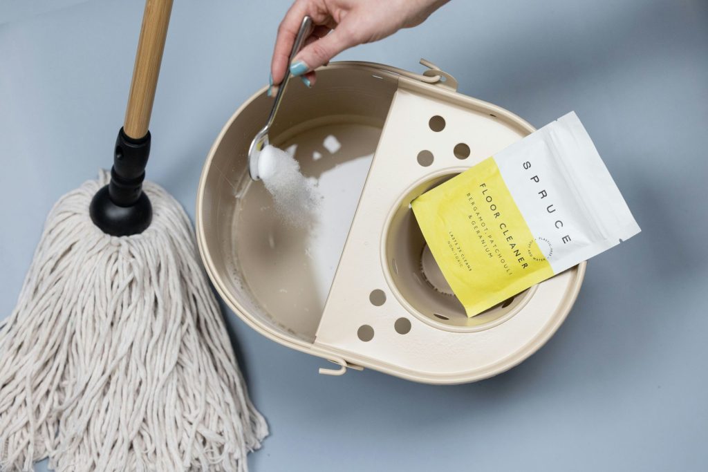 Adding cleaning powder to a mop bucket.